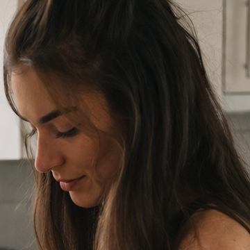 Gesicht einer dunkelhaarigen Frau, die nach unten schaut